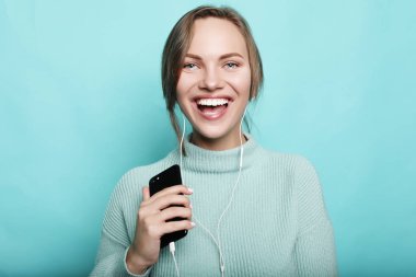 Kulaklıklı güzel genç bir kadın müzik dinliyor. 