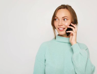  Güzel, neşeli bir kadın cep telefonuyla konuşuyor.