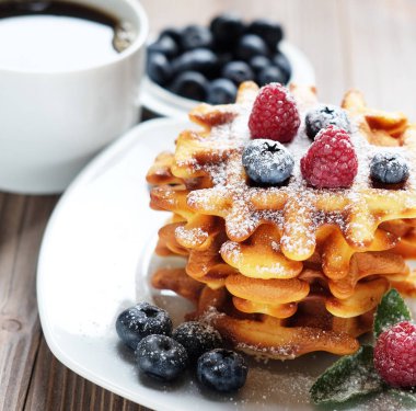 Waffle beyaz plaka ve kahve, çilek ile yakın çekim.