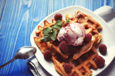Dondurma ve mavi ahşap arka plan üzerinde taze çilek ile Belçika waffle tabak