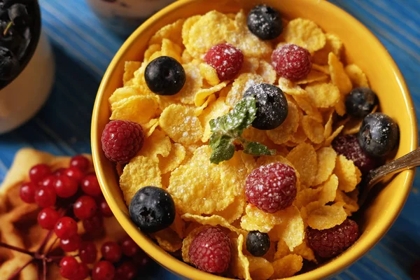 Desayuno saludable. Copos de maíz con frambuesas y arándanos, granola con yogur y bayas, obleas y leche . — Foto de Stock