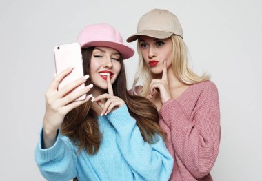  Hippi kıyafetli iki genç kız, akıllı telefondan selfie çekiyor.. 