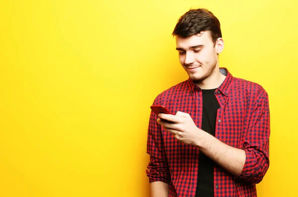 Glücklicher junger Mann telefoniert auf gelbem Hintergrund — Stockfoto