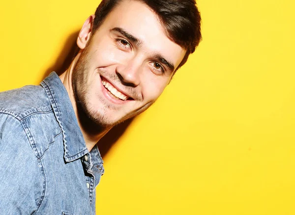 Porträtt av ung leende man stående mot gul bakgrund — Stockfoto