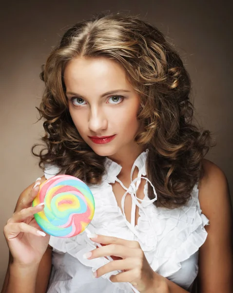Beauty curly girl portrait holding colorful lollipop. — Stock Photo, Image