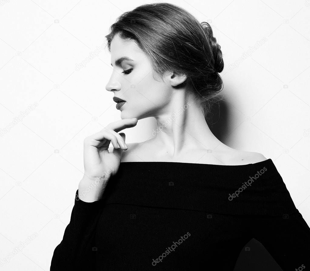 Young beautiful woman wearing black dress posing over white back