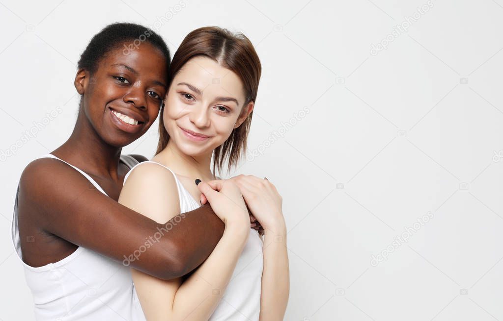 Shot of happy interracial homosexual couple hugging.African-American girl and her charming Caucasian girlfriend.