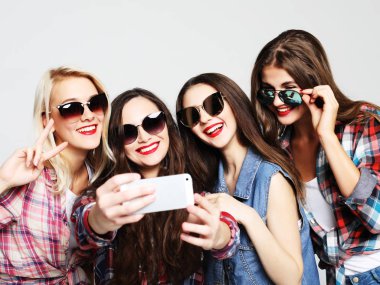 Akıllı telefonlu mutlu genç kızlar selfie çekiyor.