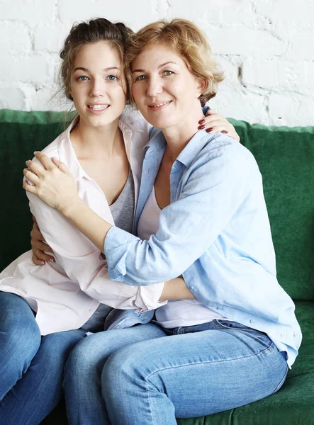 Hermosa mamá mayor y su hija adulta están abrazando, mirando a la cámara y sonriendo —  Fotos de Stock