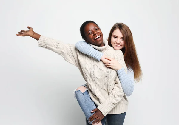 Cheerful European and African women in good mood over white background. — Stock Photo, Image