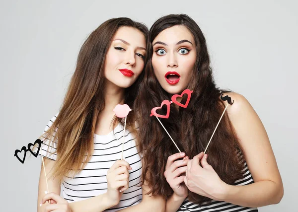 Δύο κομψά σέξι κορίτσια καλύτερες φίλες κρατώντας χάρτινα μπαστούνια κόμμα — Φωτογραφία Αρχείου