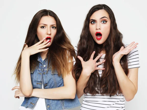 Dos amigas jóvenes divirtiéndose. Ambos haciendo caras sorprendidas. — Foto de Stock