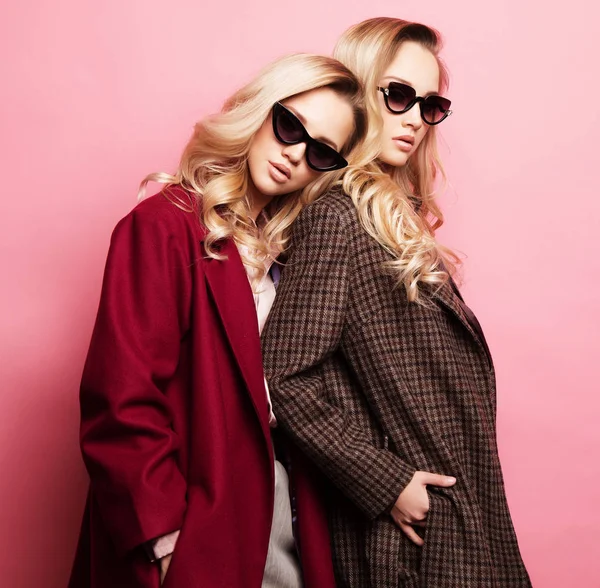 Modieuze twee blonde vrouwen in een jas met een zonnebril. Mode herfst winter foto. — Stockfoto