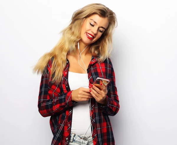 Happy young woman  listening to music from smartphone over white — Stock Photo, Image