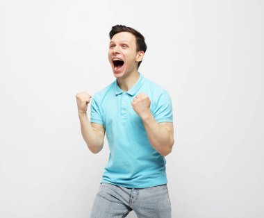 Genç adam beyaz arka planda zaferi kutluyor