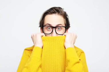  Sarı kazak giyen çekici bir adam şaşkınlık ve şaşkınlık içinde şaşırdı ve şaşırdı.