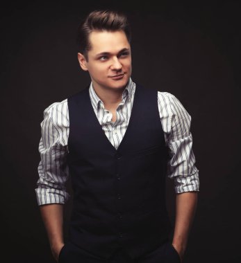 Genç adam arka planda poz veriyor.