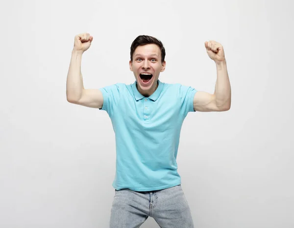 Joven celebrando la victoria sobre fondo blanco — Foto de Stock