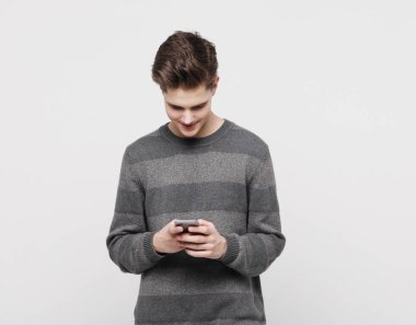 Beyaz arka planda SMS yazan mutlu genç adam.