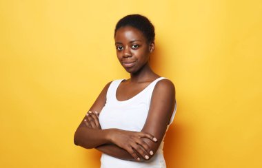  Güzel, mutlu, genç bir Afrikalı kadın. Sarı arka planda izole edilmiş. 