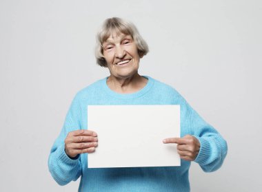 Boş reklam panosu veya kopya alanı ile yaşlı kadın
