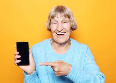 Yeni akıllı telefonlu olgun bir kadının resmi..