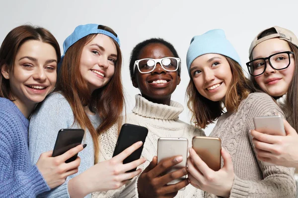 アフリカ系アメリカ人や白人女性がスマートフォンを見ています。ソーシャルネットワークでオンラインでチャット. — ストック写真