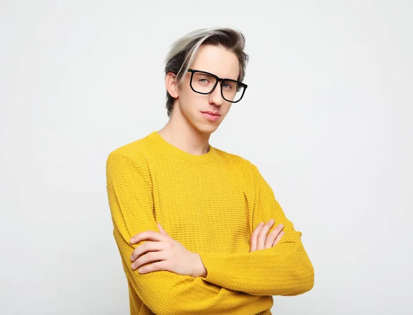 Porträtt av en smart ung man bär glasögon stående mot vit bakgrund — Stockfoto