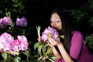 açık havada çiçek ile gülümseyen kadın
