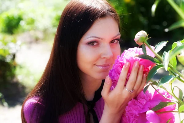 Mulher sorrindo ao ar livre com algumas flores — Fotografia de Stock