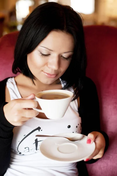 Jeune femme assise dans un café à boire du café — Photo