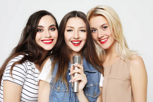 Chicas de belleza con un micrófono cantando y divirtiéndose juntos — Foto de Stock