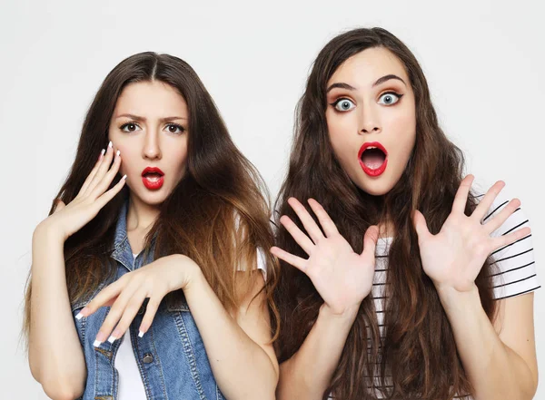 Duas jovens amigas se divertindo. Ambos fazendo rostos surpresos. — Fotografia de Stock