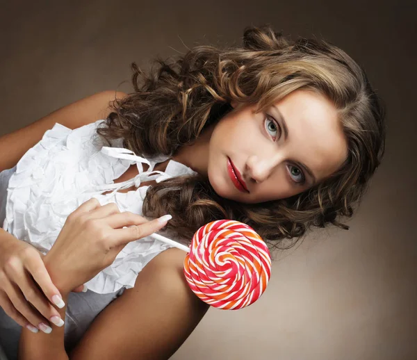 Beauty curly girl portrait holding colorful lollipop. — Stock Photo, Image