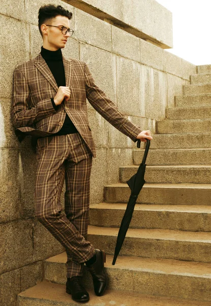 Jovem na moda em óculos com guarda-chuva em pé nas escadas — Fotografia de Stock