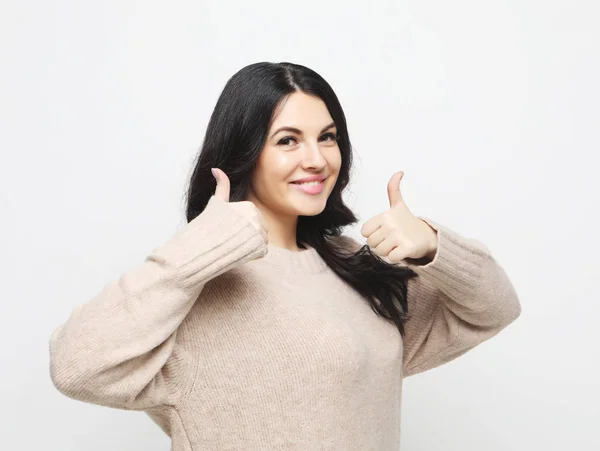 Szczęśliwa młoda kaukaska kobieta robi kciuk w górę znak i uśmiecha się radośnie, pokazując swoje poparcie i szacunek do kogoś. — Zdjęcie stockowe
