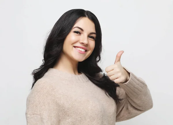 Feliz joven caucásica hembra haciendo el pulgar hacia arriba signo y sonriendo alegremente, mostrando su apoyo y respeto a alguien. —  Fotos de Stock