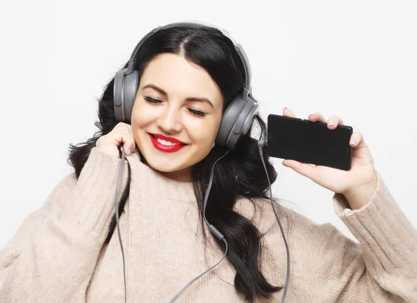 Joven mujer morena con curvas en auriculares escuchando música —  Fotos de Stock