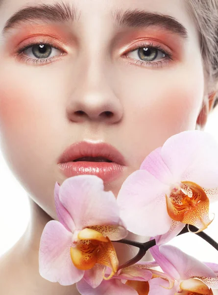 Model met perfecte make-up en roze bloemen — Stockfoto
