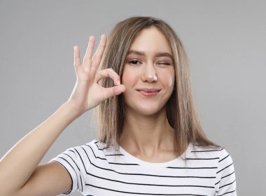 Güzel kadın sıfır, göstermek için parmaklarını kullanarak stüdyo