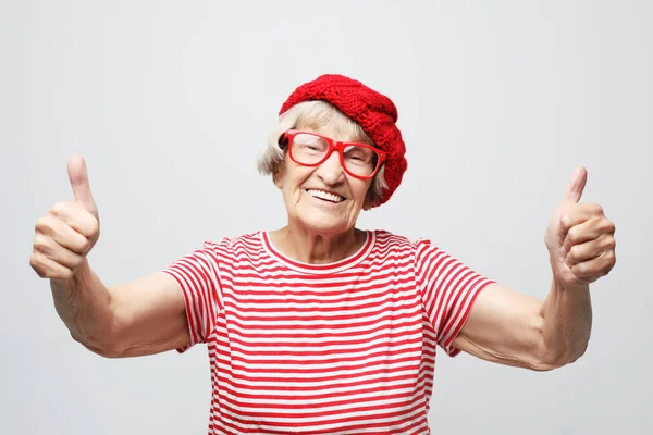 Mulher idosa dando um polegar para cima e olhando para a câmera — Fotografia de Stock