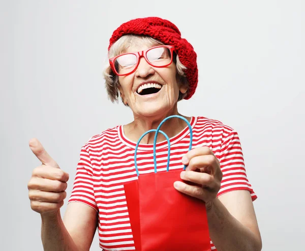 Lifestyle, holiday and people concept: elderly woman with gift bag. — Stock Photo, Image