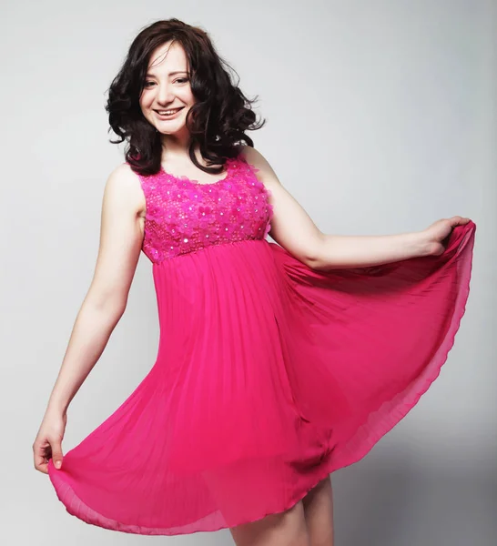 Young woman with curly hair wearing pink dress — Stock Photo, Image