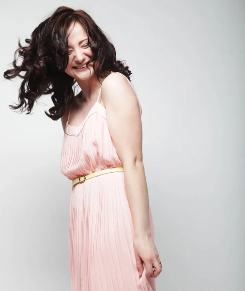 Young woman with curly hair wearing pink dress — Stock Photo, Image