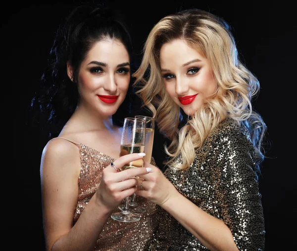 Zwei Glamour-Frauen in Luxus-Glitzerpailletten-Kleid trinken Champagner und haben Spaß. — Stockfoto