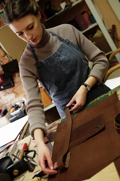 Vrouw werkt in een zak maken Studio, snijdt Details — Stockfoto