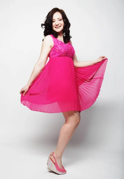 Young woman with curly hair wearing pink dress — Stock Photo, Image