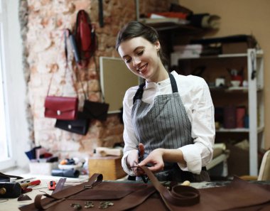 kadın bir çanta yapma stüdyosu çalışır, detayları keser