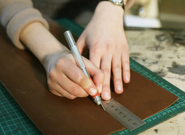 Vrouw werkt in een zak maken Studio, snijdt Details — Stockfoto