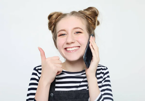 Estilo de vida y concepto de la gente: Retrato de una chica casual satisfecha sosteniendo el teléfono móvil y mostrando un gesto bien aislado — Foto de Stock